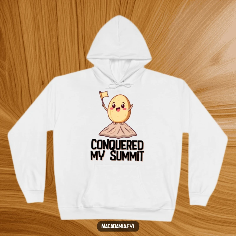 Funny Macadamia Nut character waving a miniature flag atop a small mountain peak, perfect for cozy, humorous celebration wear.