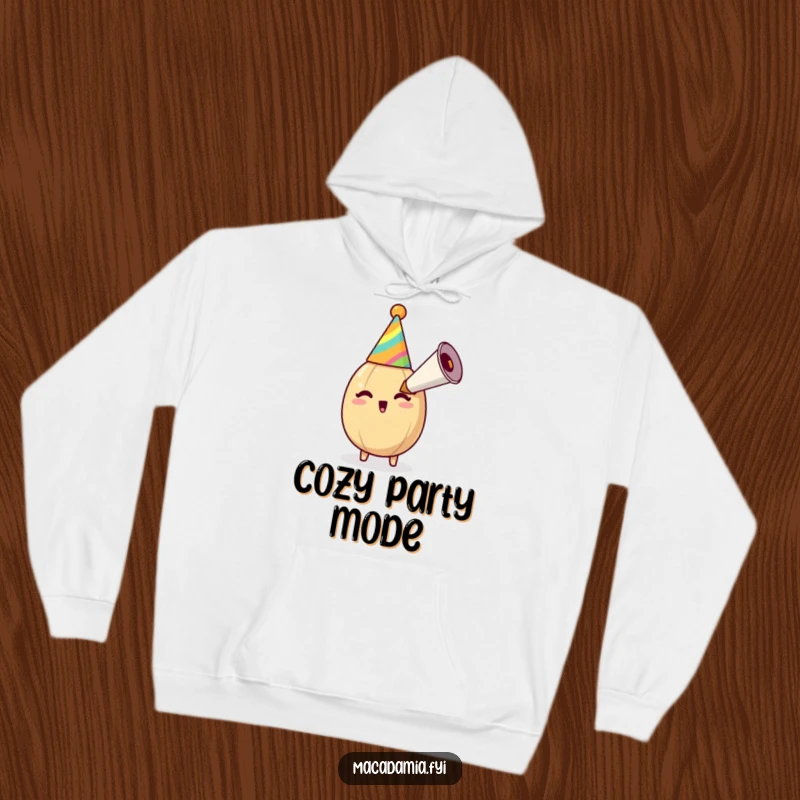 Funny macadamia nut in a party hat blows an oversized party horn, radiating cheerful, nutty energy on a cozy hoodie.