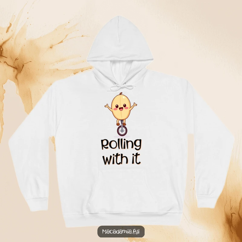Funny hoodie showcasing a joyful macadamia nut riding a unicycle with arms outstretched, symbolizing adventure and cozy fun.